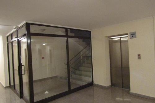 a glass elevator in a building with a staircase at Ski Apartment D50 Cedar Lodge 4 in Bansko