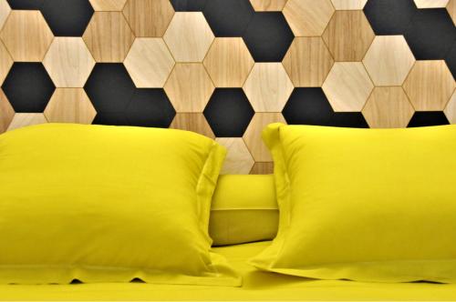 a yellow bed with a yellow pillow and a wall at Hôtel Saint Jean in Tours
