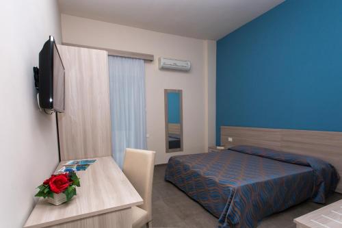 a bedroom with a bed and a table with a flower on it at Hotel Santa Caterina Village Club in Scalea