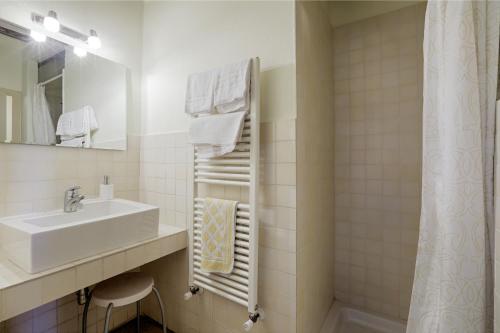 Baño blanco con lavabo y espejo en Attilio Camere, en Siena