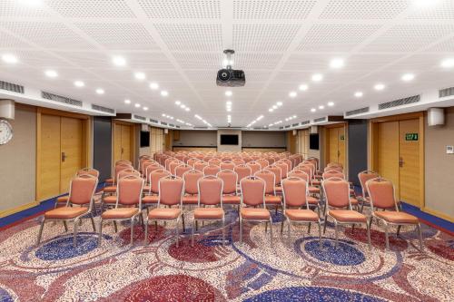 an empty room with rows of chairs on a rug at Park Dedeman Trabzon in Trabzon
