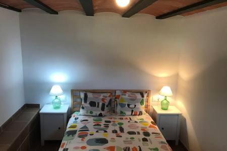 una camera con un letto e due lampade su due tavoli di Casita en plena naturaleza con piscina y wifi gratis a Canet de Mar