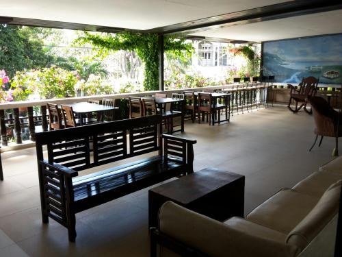 a restaurant with a couch and tables and chairs at Travelbee Heritage Inn in Dapitan