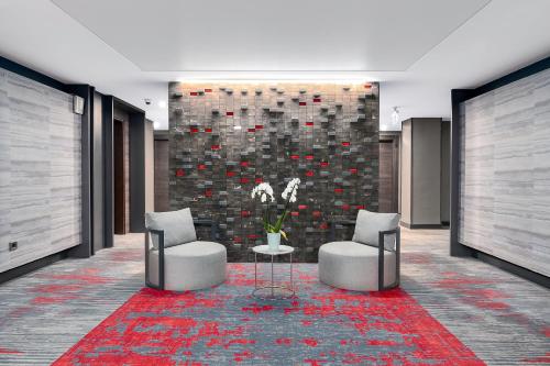 a lobby with two chairs and a table and a wall at Park Dedeman Trabzon in Trabzon