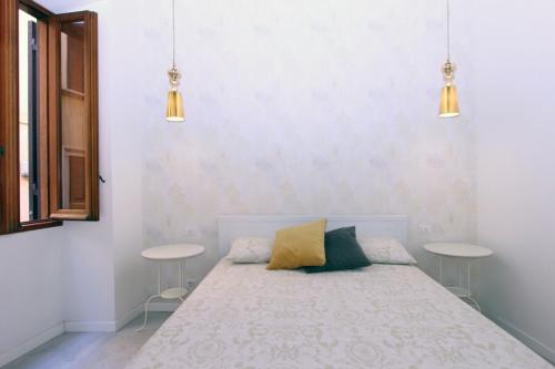 a bedroom with a bed with two tables and two pendant lights at Monte Giordano Flats in Rome