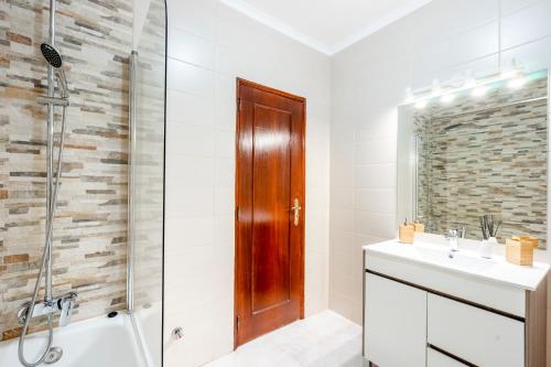 een badkamer met een douche en een wastafel bij My Place @ Faro Ria Views in Faro