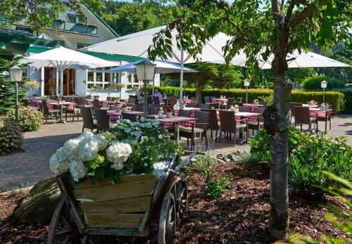 a cart with flowers in it in front of a restaurant at Landhotel Kallbach - 4 Sterne SUPERIOR in Hürtgenwald