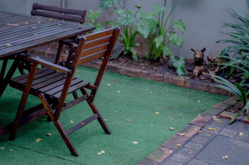 a wooden chair sitting next to a table and a dog at 314 on Clark Guest House in Pretoria