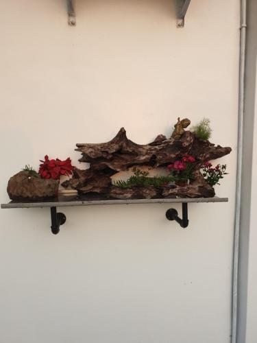 a shelf with flowers and logs on a wall at A-Mong B&B (Qingshui) in Qingshui