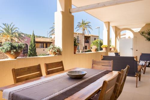 a dining table and chairs on a balcony with a view at Appartamenti Shardana in Villasimius