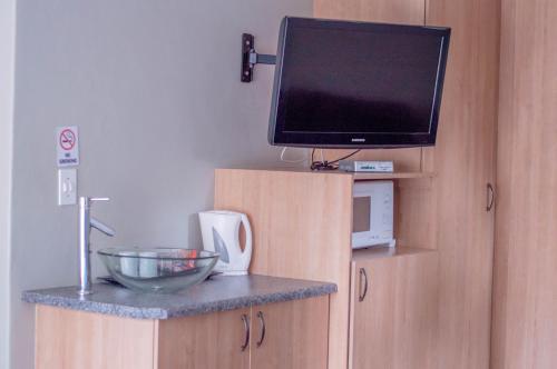 a kitchen with a tv and a bowl on a counter at 314 on Clark Guest House in Pretoria
