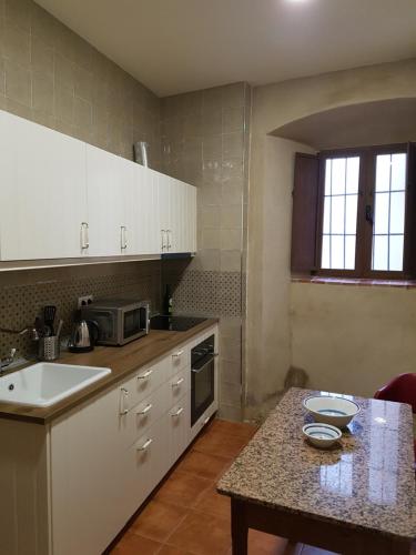 a kitchen with white cabinets and a counter top at Apartamentos Altozano in Trujillo