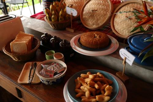 a table topped with plates and bowls of food at Anurak Community Lodge - SHA Plus in Khao Sok