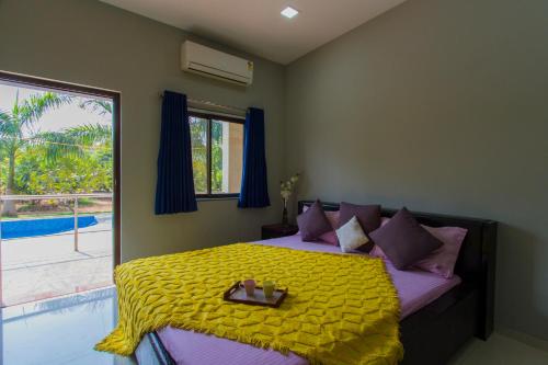 a bedroom with a bed with a tray on it at StayVista at Shubmann Villa with Pvt Pool & River View in Rudāna
