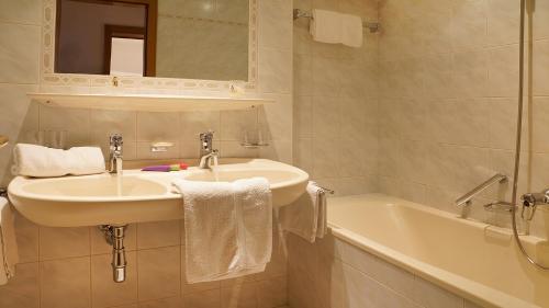 un bagno bianco con lavandino e vasca di Appartment Eichhorn a Sankt Anton am Arlberg