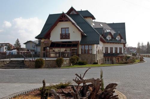 a large house with a green roof on a street at Skalny Dworek in Nowy Targ