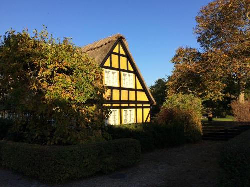 a small house with a thatched roof at Troense Bed and Breakfast by the sea in Svendborg
