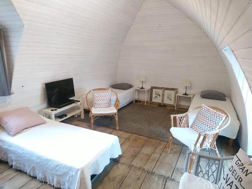 a room with two beds and a tv and two chairs at La Soubeyranne in Mende