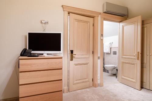 a bathroom with a television on a dresser next to a toilet at Lacul Verde Resort in Ploieşti