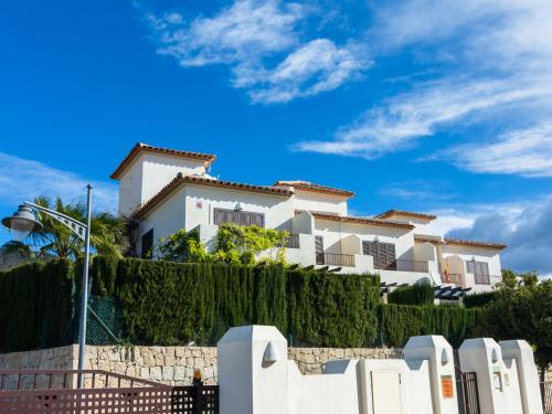 un edificio blanco frente a una valla en Belvilla by OYO Los Olivos, en Benidorm