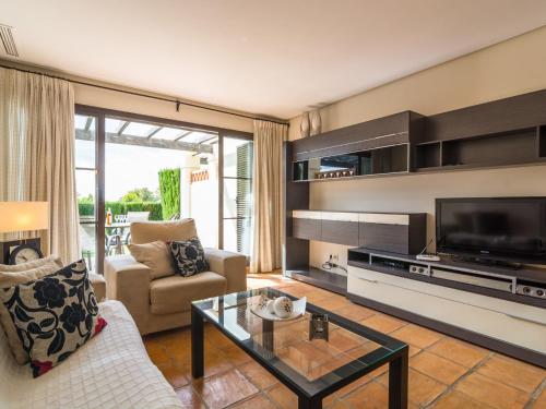 uma sala de estar com uma televisão, um sofá e uma mesa em Belvilla by OYO Los Olivos em Benidorm