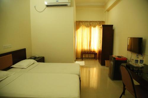 Un pat sau paturi într-o cameră la Kallada Residency
