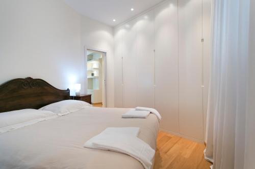 a white bedroom with a bed with towels on it at Apartment San Domenico in Siena