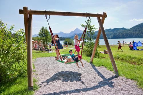 a group of children playing on a swing set at Appartement-Hotel Seespitz in Füssen