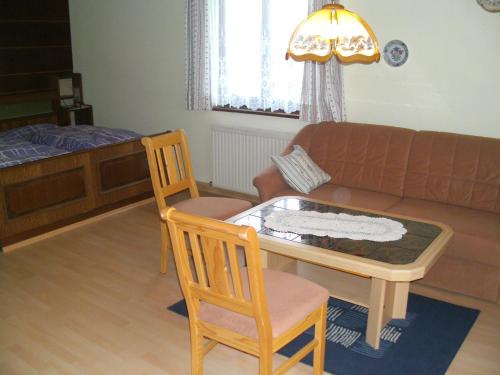 a living room with a couch and a table and chairs at Bauernhof Manuela Perner in Nussdorf am Attersee