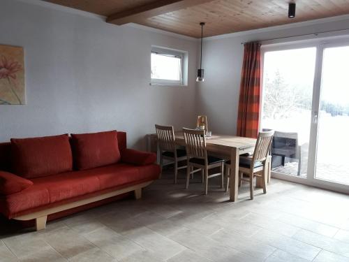 a living room with a red couch and a table at Ferienwohnung Moralé in Seefeld in Tirol