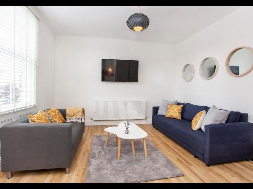 un soggiorno con divano blu e tavolo di Apartment 5 Blue Bridge Court a York
