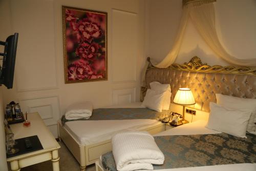 a hotel room with two beds and a lamp at La Perla Boutique Hotel in İskenderun
