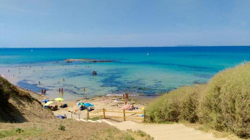 a group of people on a beach with umbrellas at Apartment Luisa in Tergu