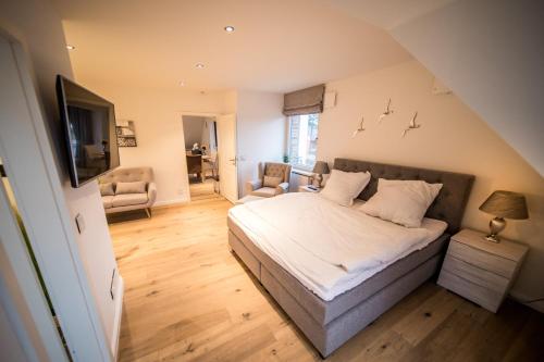 a bedroom with a bed and a chair and a television at Lichtmeer in Westerland (Sylt)