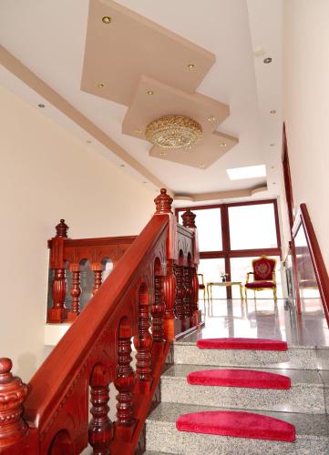 a staircase with red carpeting and a chandelier at Hotel Kennedy in Nürnberg
