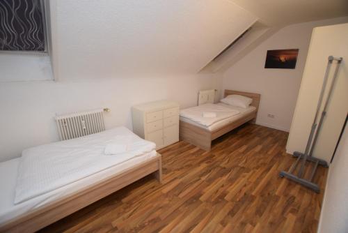 2 letti in una piccola camera con pavimenti in legno di Apartment Ostfildern-Nellingen II a Ostfildern