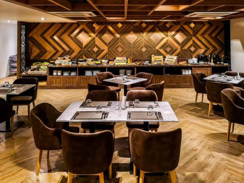 a restaurant with tables and chairs and a bar at Zayn Hotel Bangkok - Airport Link Access in Bangkok