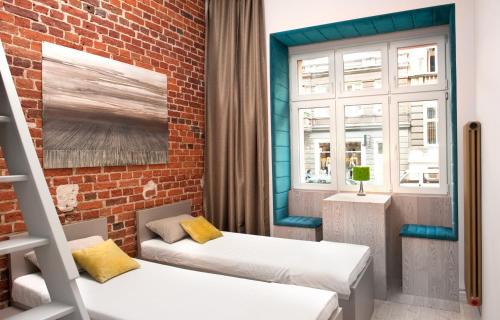 Pokój z 2 łóżkami i ceglaną ścianą w obiekcie MoHo M we Wrocławiu