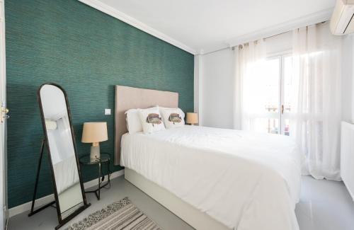 マドリードにあるSuper View Apartment Plaza Mayorの緑の壁のベッドルーム1室(白いベッド1台付)