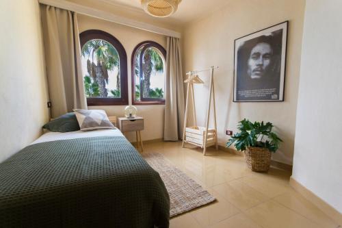 a bedroom with a bed and two windows at Dream Bay Home in San Bartolomé