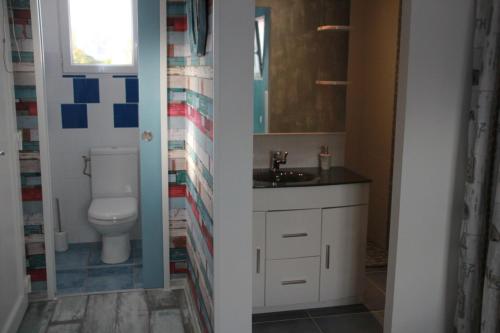 une salle de bain avec toilettes et lavabo dans l'établissement KARABI, à Barbâtre