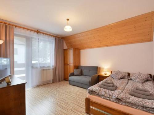 salon z łóżkiem i kanapą w obiekcie Nad Strumyczkiem - pokoje gościnne - Apartamenty z przymróżeniem oka w Szczyrku