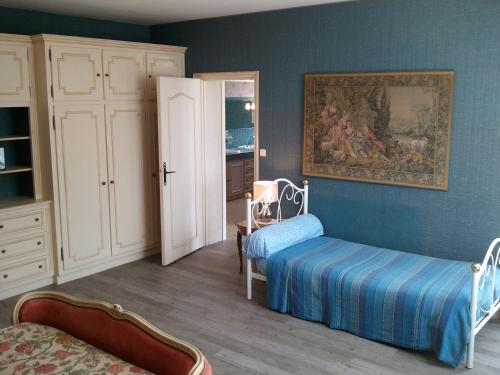 ein Schlafzimmer mit zwei Betten und einem Gemälde an der Wand in der Unterkunft Mas du Trezon in Cholet