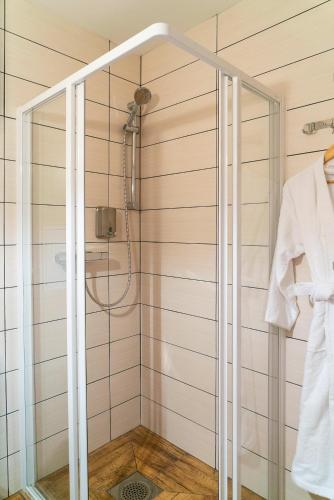 a shower with a glass door in a bathroom at Godart Rooms Guesthouse in Tallinn