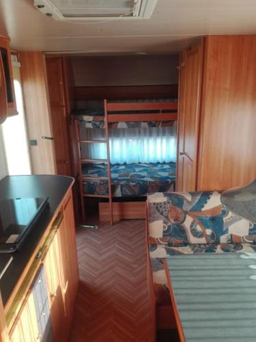a room with a couch and a bunk bed at Sosta Camper La Specchia in San Pietro in Bevagna
