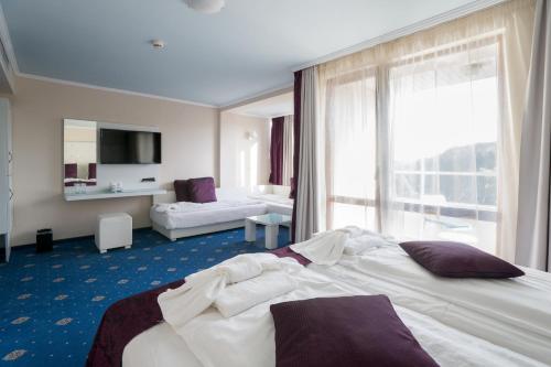a hotel room with a bed and a large window at Perla Royal Hotel - All Inclusive in Primorsko