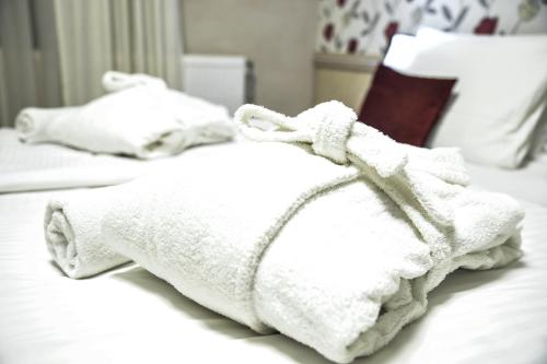 a white towel laying on top of a white bed at Hotel Centar Balasevic in Belgrade