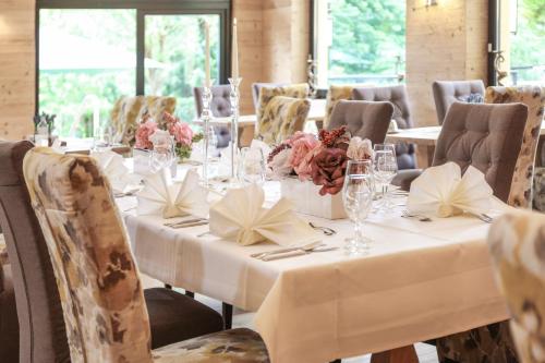 a long table with white table cloths and flowers on it at Parkhotel Luise Bad Herrenalb in Bad Herrenalb