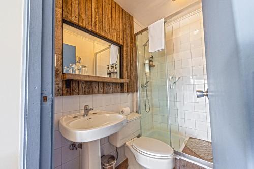 y baño con lavabo, aseo y ducha. en Kau Lodge, en Puerto Natales