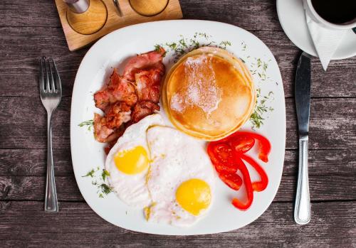 a plate of breakfast food with eggs bacon and a cup of coffee at San Martino Vald'Afra in Sansepolcro